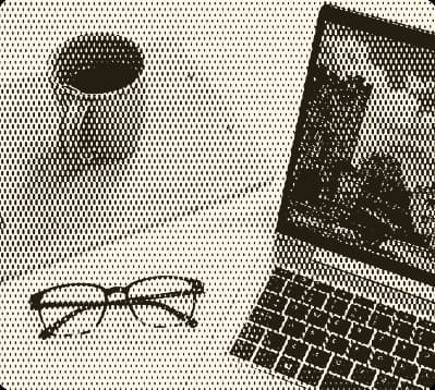 Glasses, laptop and coffee cup on a desk