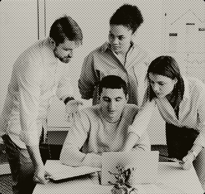 Group of people gathered around a laptop